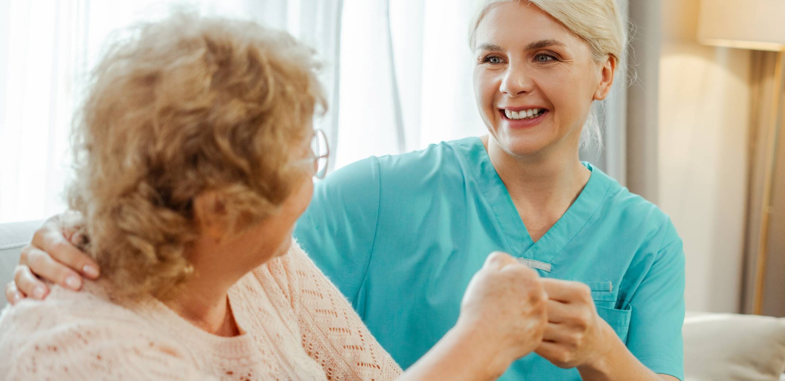 carer holding hands with elderly lady